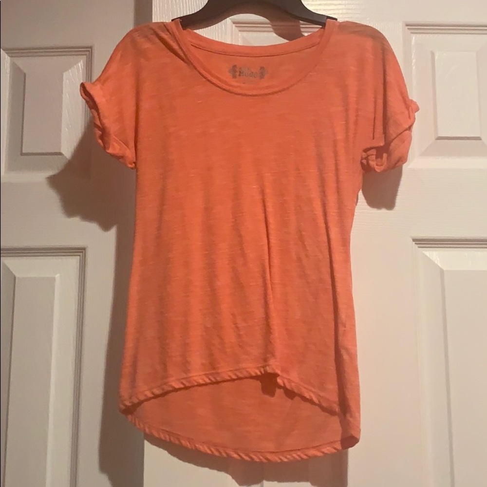 orange/coral tee with rolled sleeves